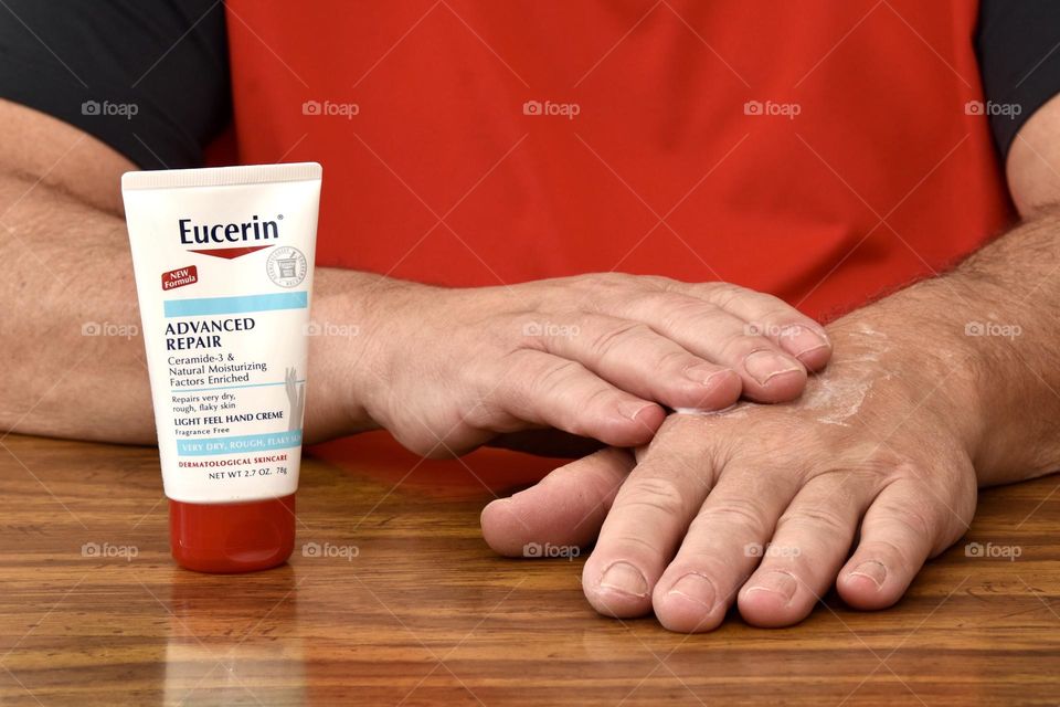 Man putting on hand lotion