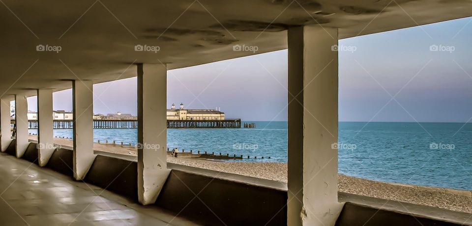 Hastings pier and beach, viewed from the seafront underpass known as Bottle Alley.