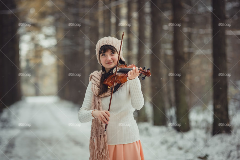 Teenage girl portrait with violin in winter park