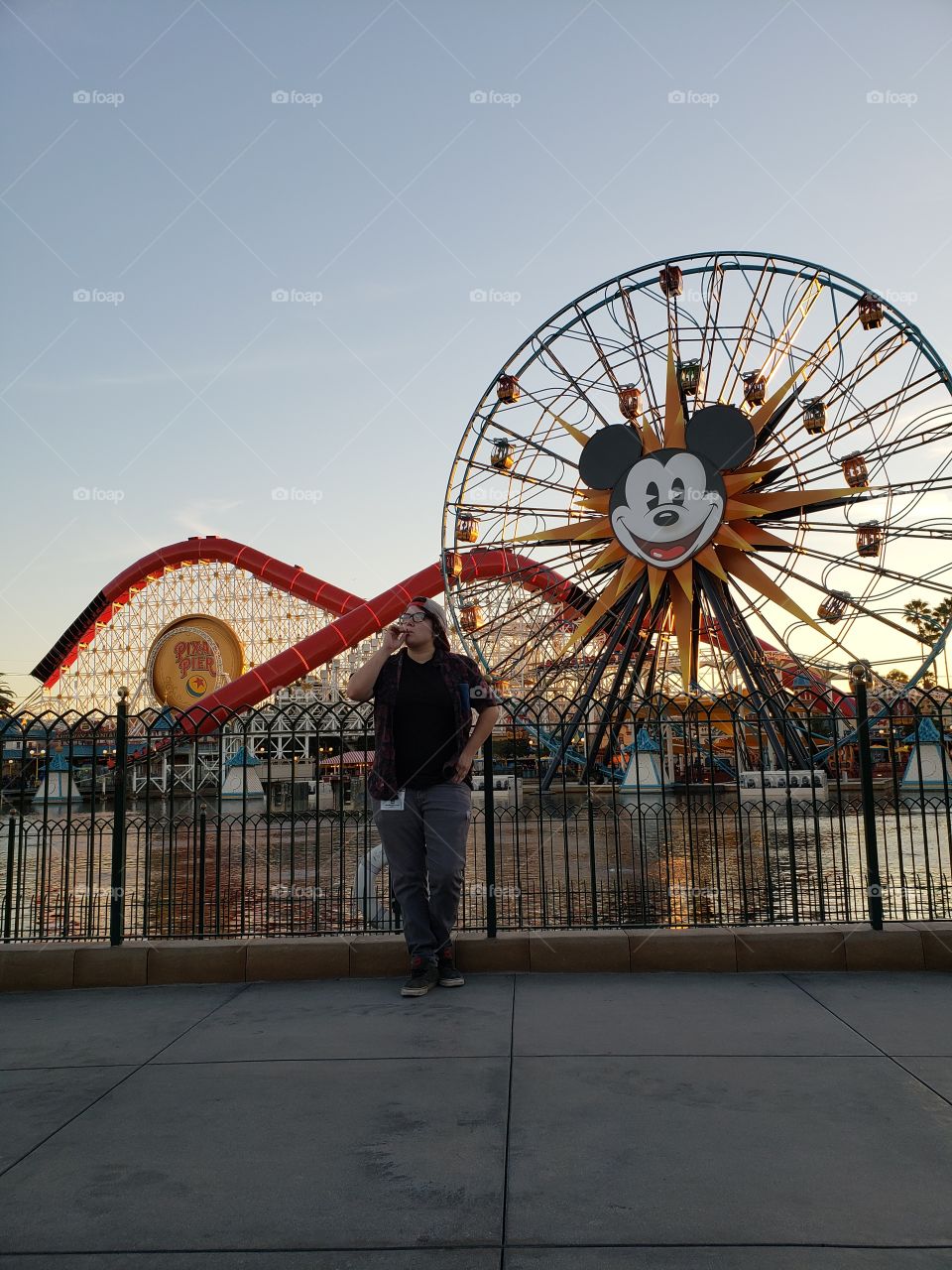 The sunset illumimates my girfiend having a smoke in front of Disneyland's Paradise Pier.