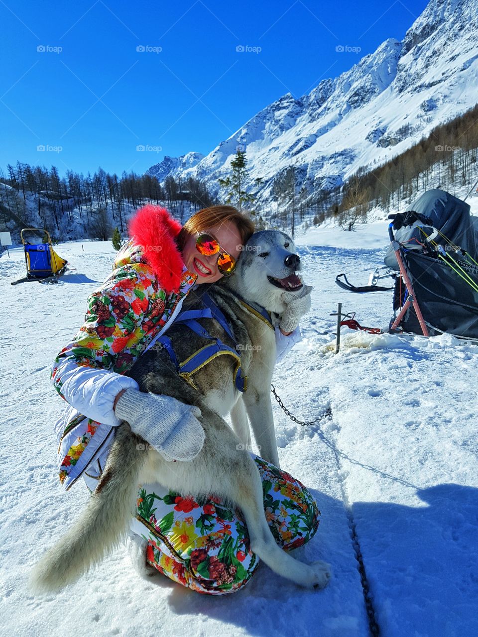 Happy woman with her pet dog in hoodie during winter