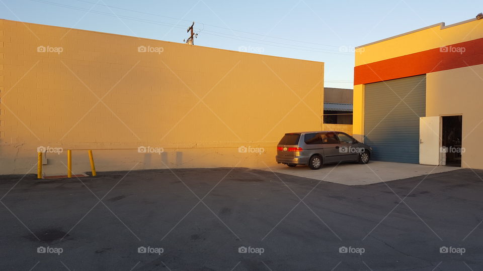 mini van parked near warehouse at sunset