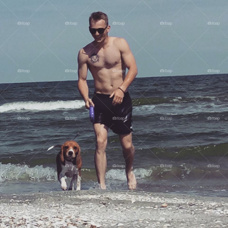 Shirtless man with her dog at sea