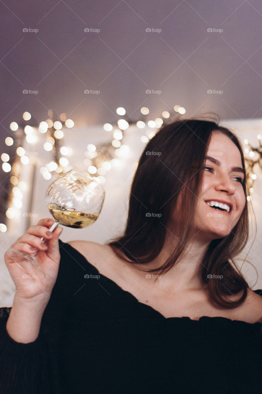 woman smiling while drinking a glass of wine