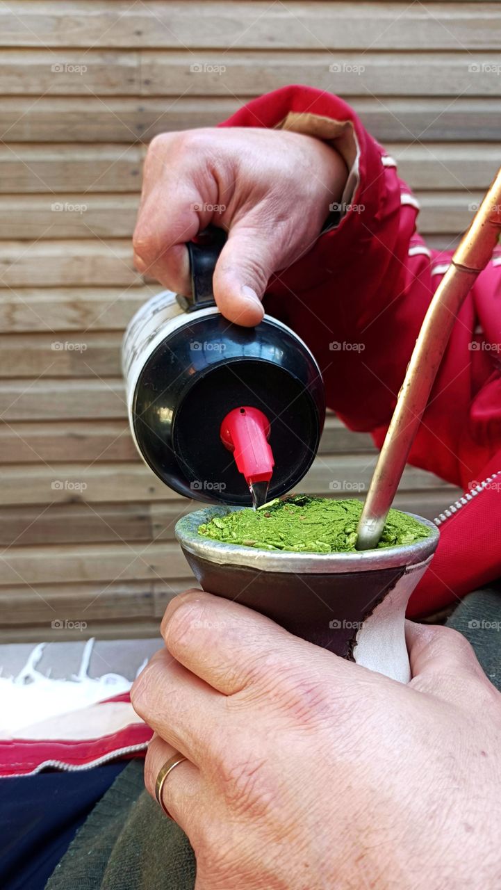 Man drinking chimarrão in a red coat, a traditional drink from the southern states of Brazil