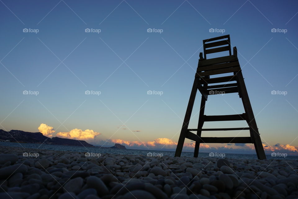 Sunset#beach#clouds#stones#mountain#lifeguard#chair#moment