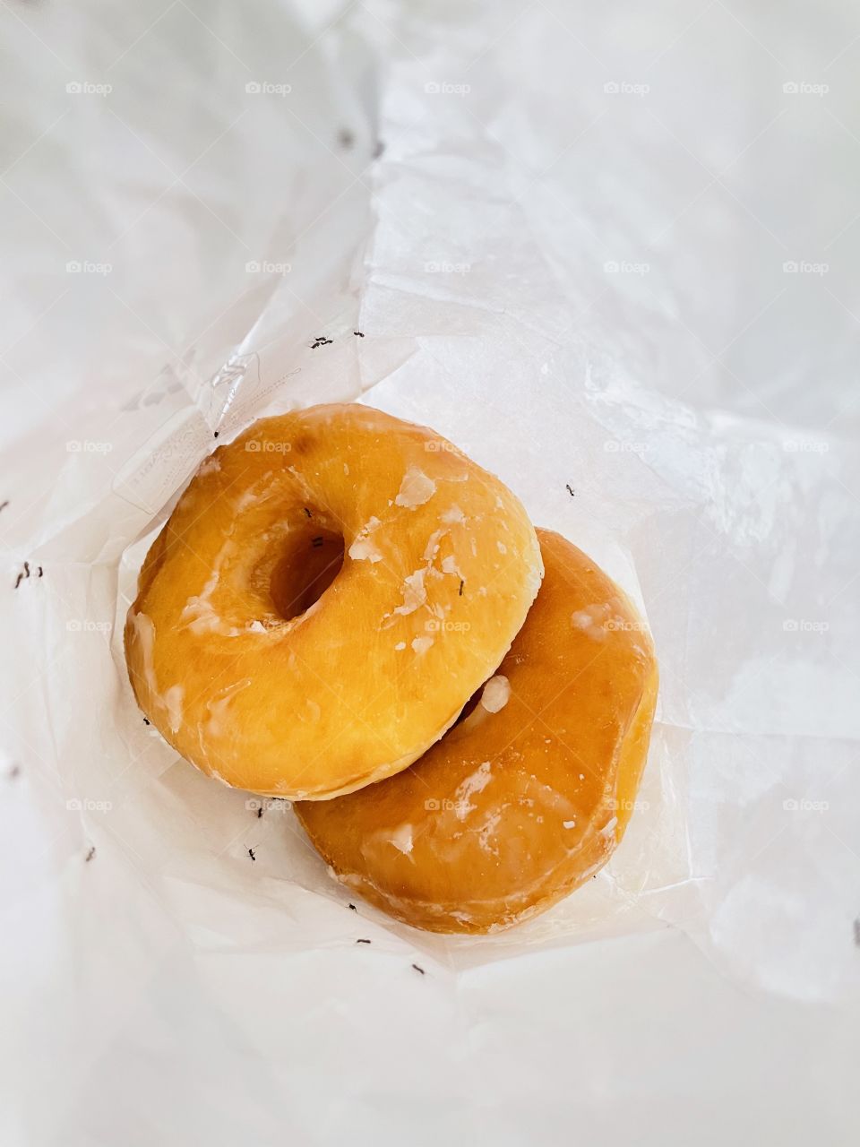 Close up shot of donuts with ants inside the paper bag