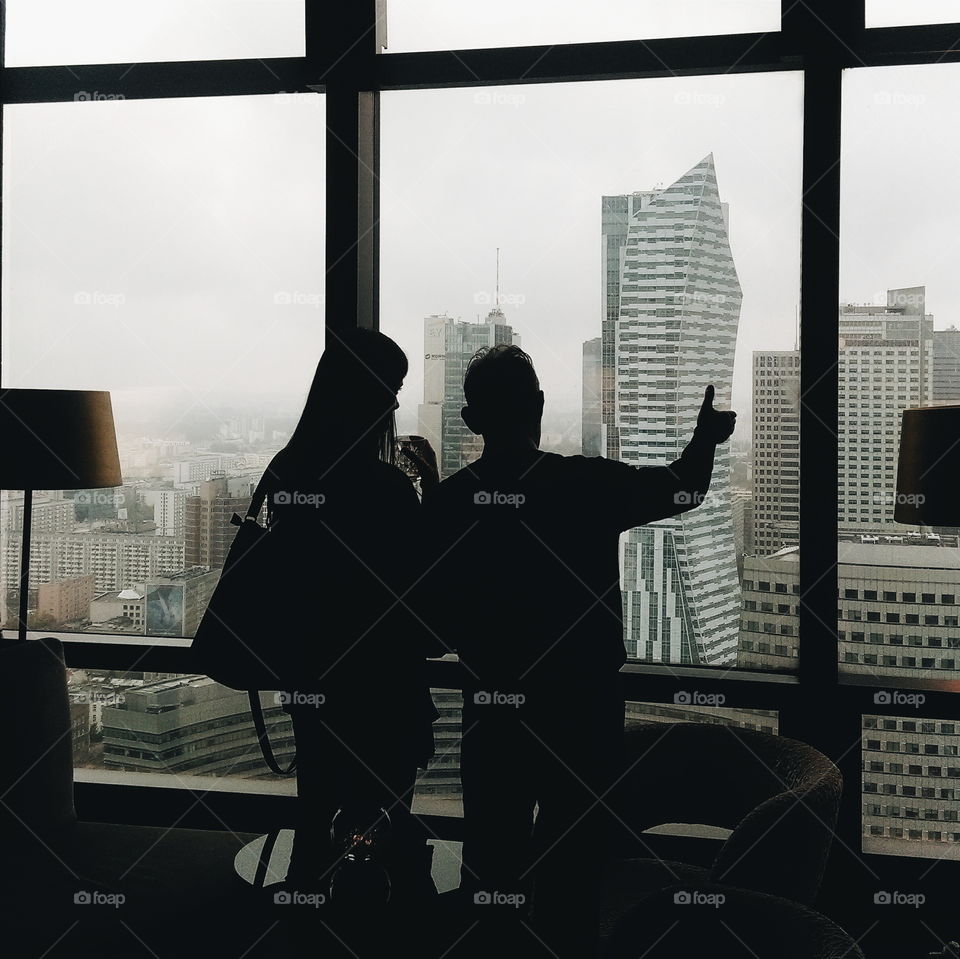 Silhouette of People Looking Out Window at Warsaw