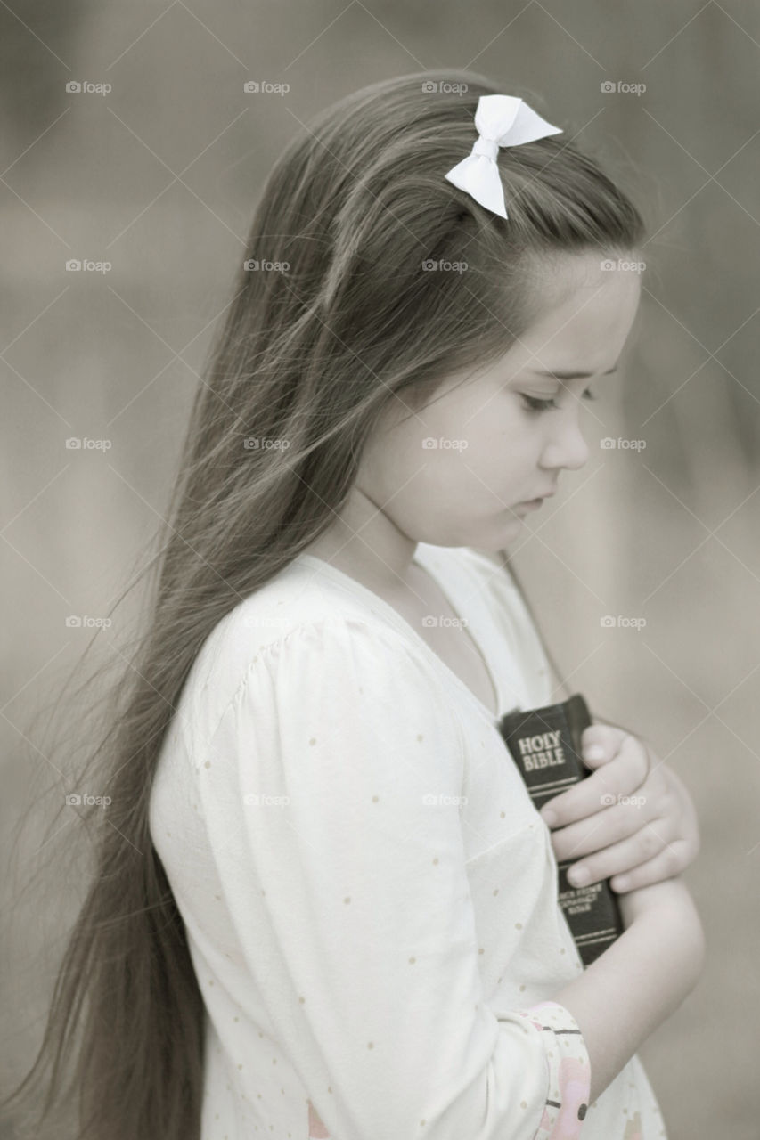 Girl praying holding bible