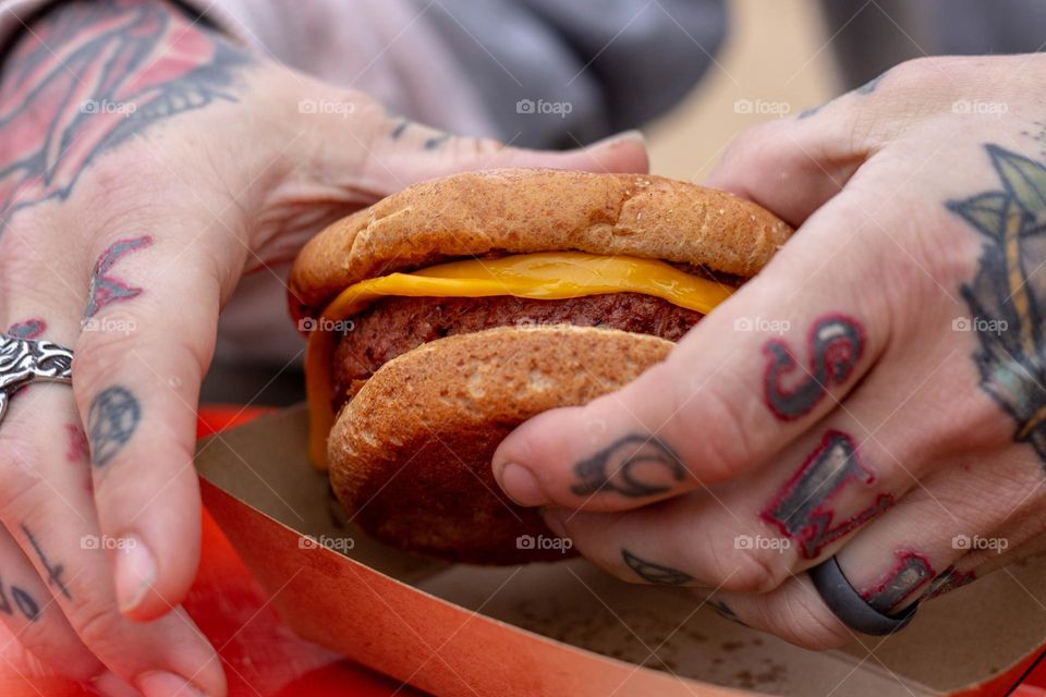Tattooed man grabbing a burger