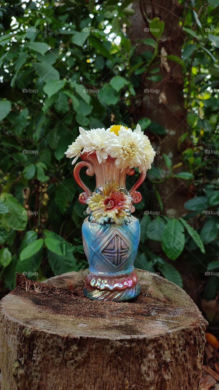 Beautiful white flowers in a colourful flowerpot with a flower sculpture, Flowers in a vase, colourful vase, white flowers in a vase