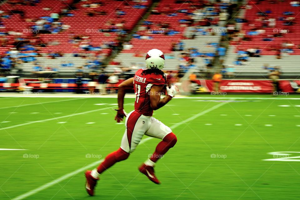 A professional football player runs down the sidelines during a pregame warmup session