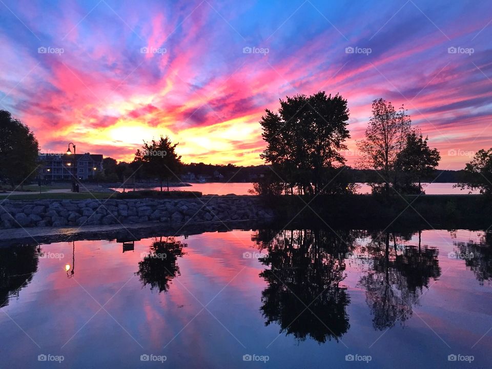 Reflection of trees on lake during sunset