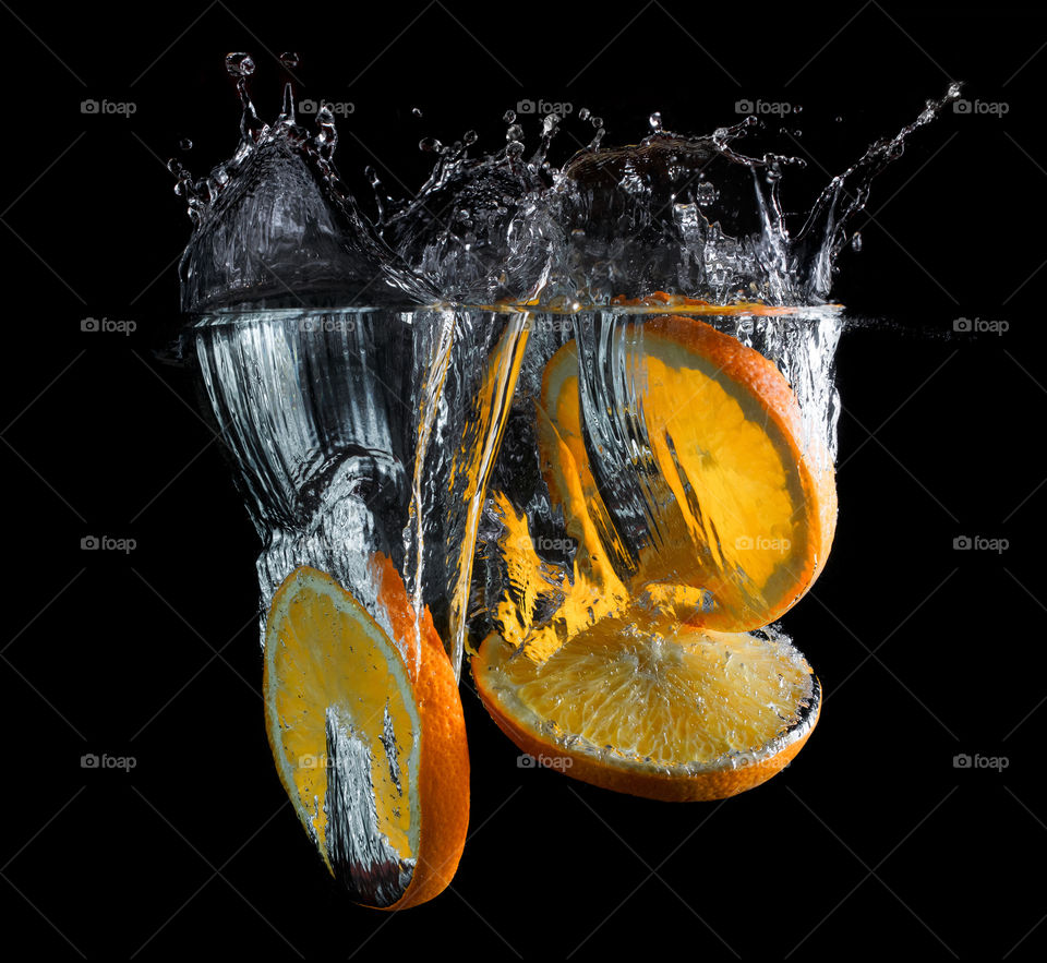 Rodajas de naranjas callendo en agua