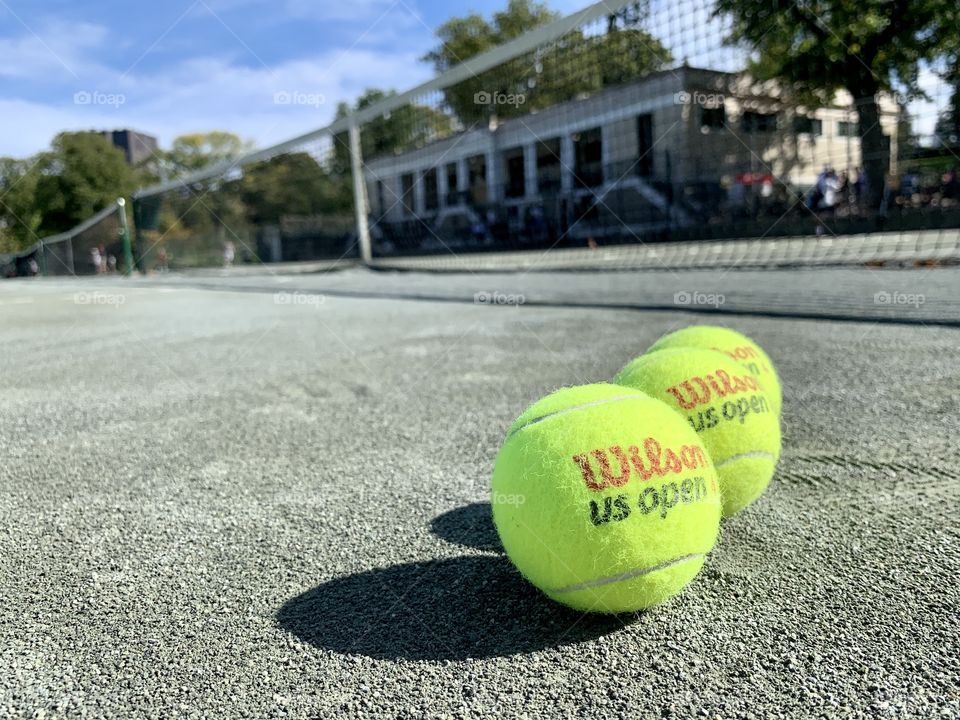 Wilson us open tennis balls. Reflection of the net and the balls at tennis courts.