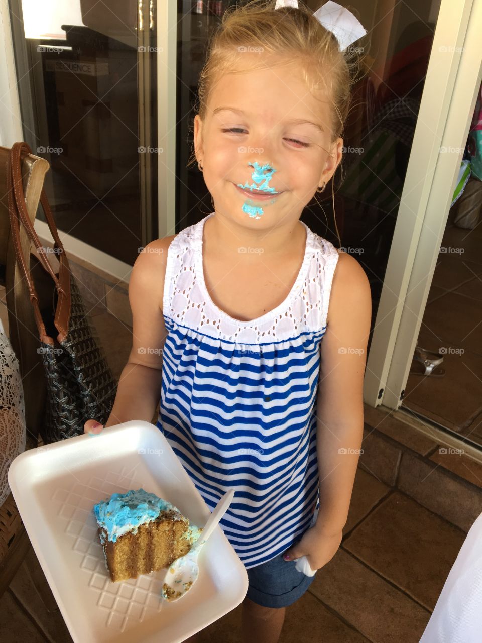 Cute little girl with cake on her face 
