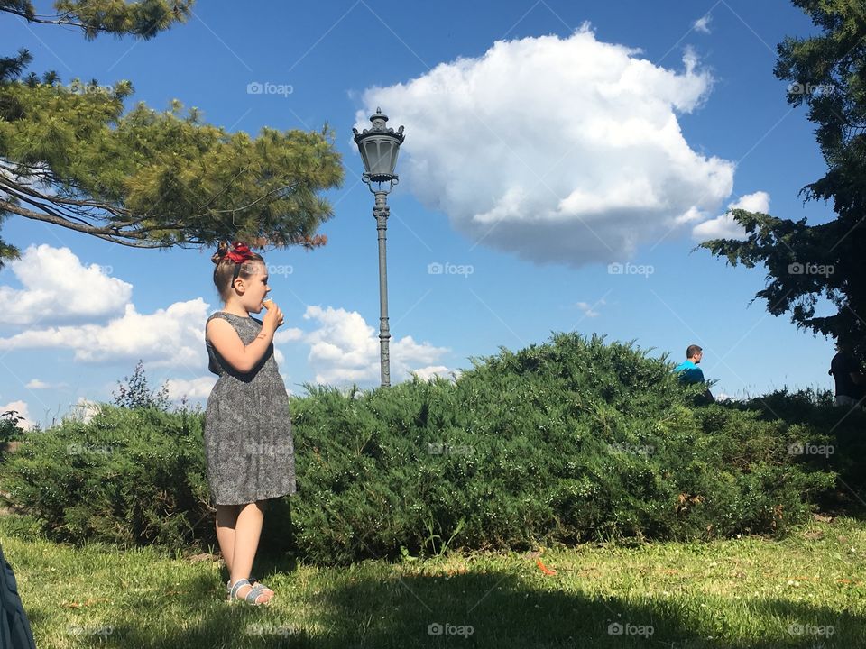 Little girl eating ice cream at beautiful scenery