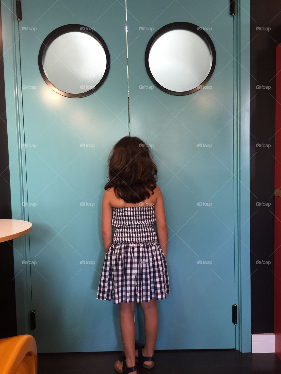 Rear view of girl standing in front of lift