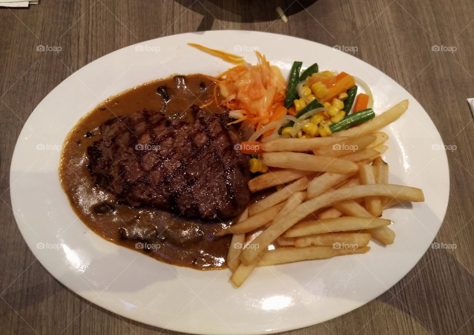 Sirloin steak, french fries and vegetables