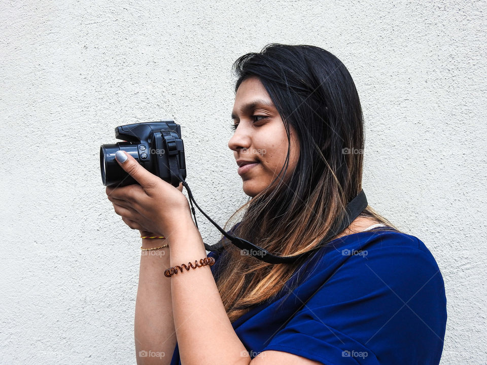 Young Woman Taking Photos With Her Favorite Gadget A Camera