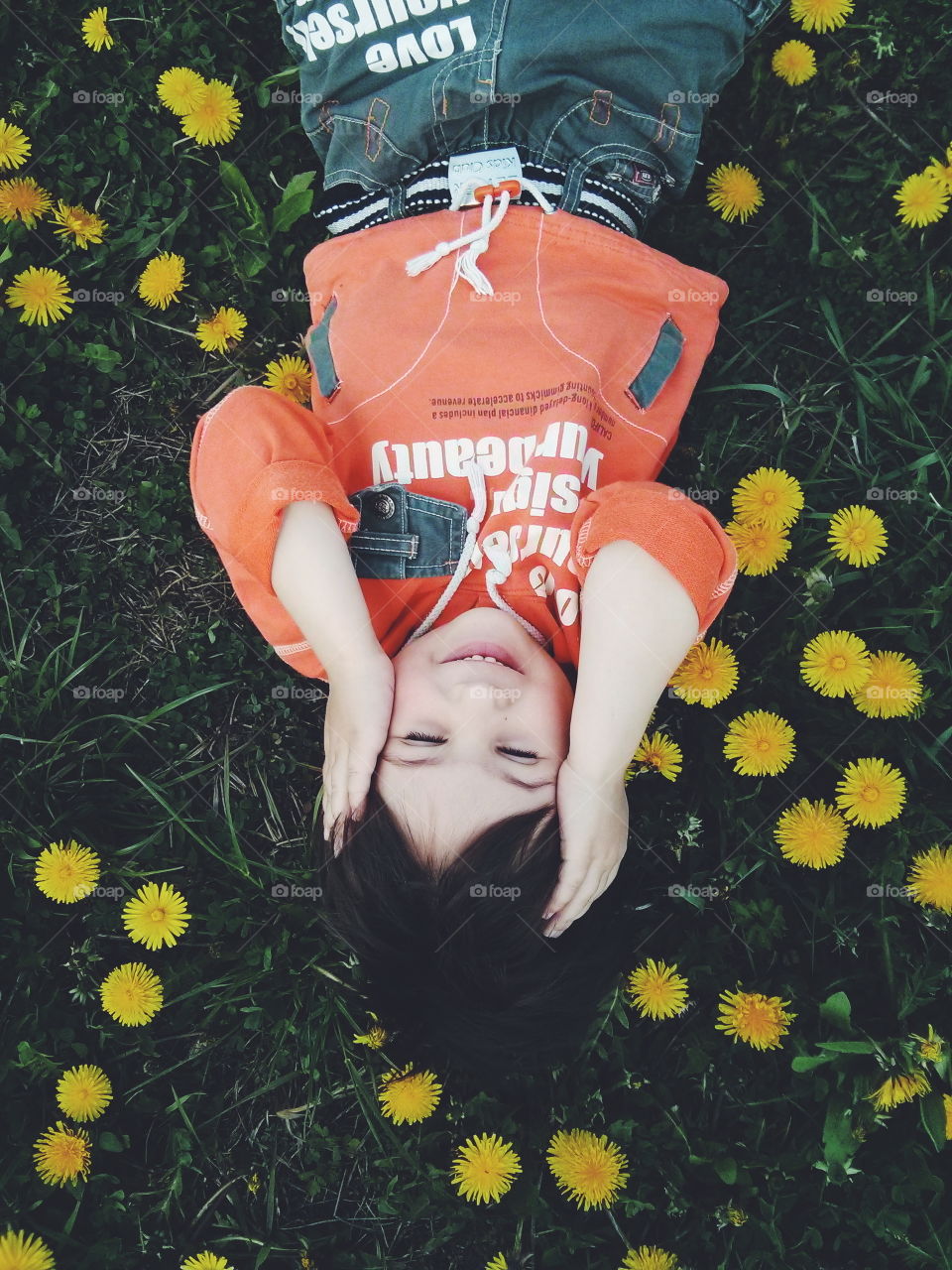 Boy in the yellow dandelions. Boy lying in the yellow dandelions