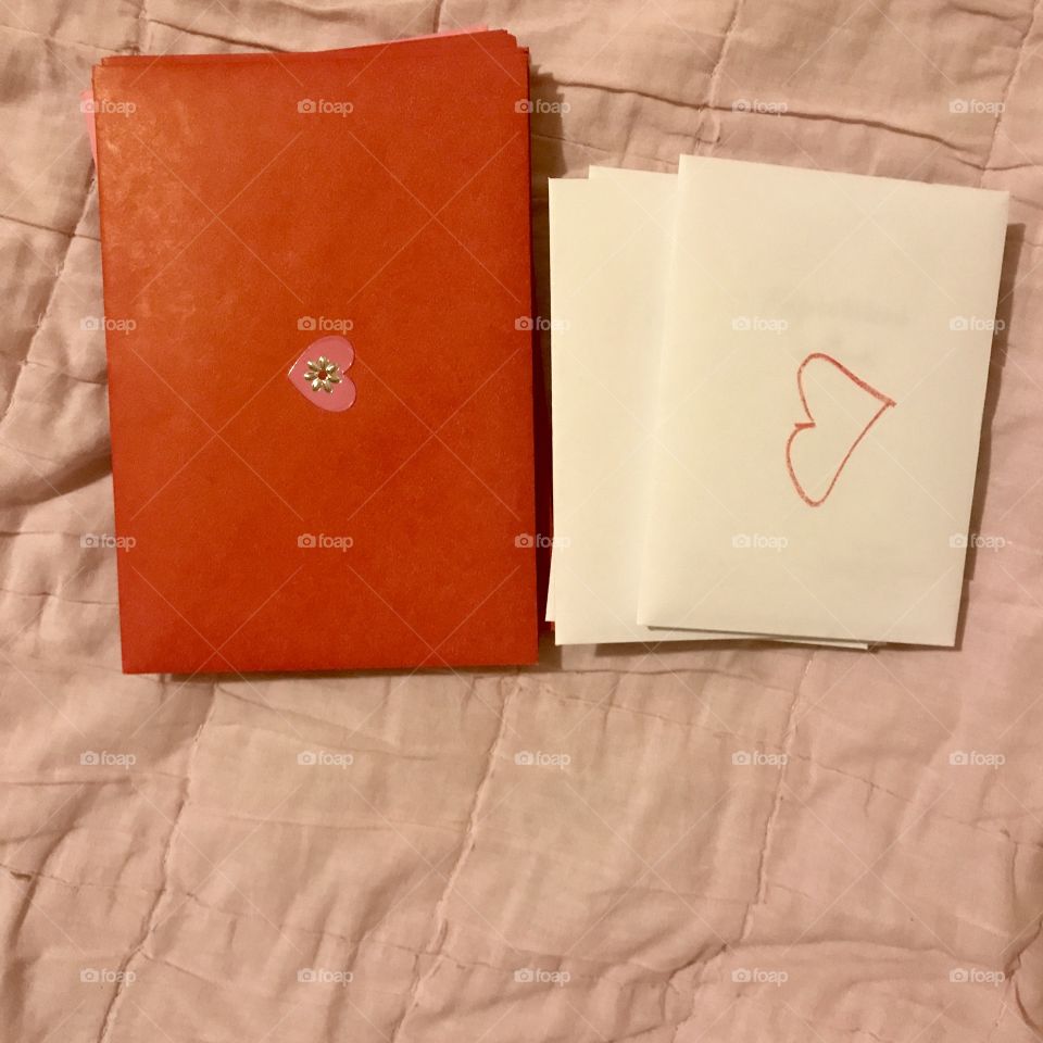 Happy Valentine’s Day. Hand written Valentine’s Day cards in red and white envelopes on a pink blanket, background. USA, America 