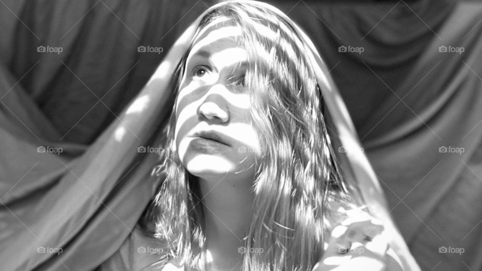Read through the Blinds; woman sitting with sunlight coming through blinds; Noir, Black and White