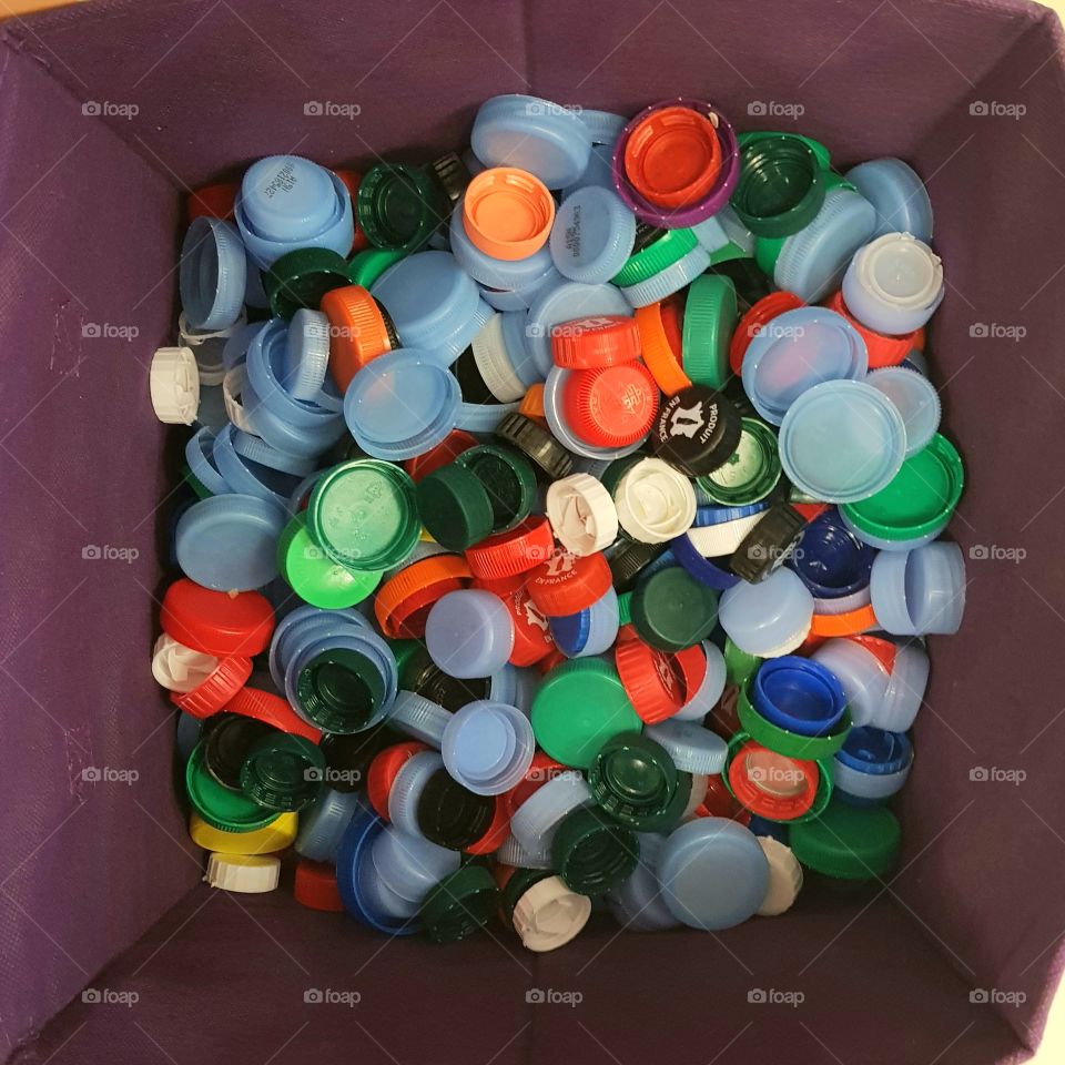 Recycling bin full of plastic tops