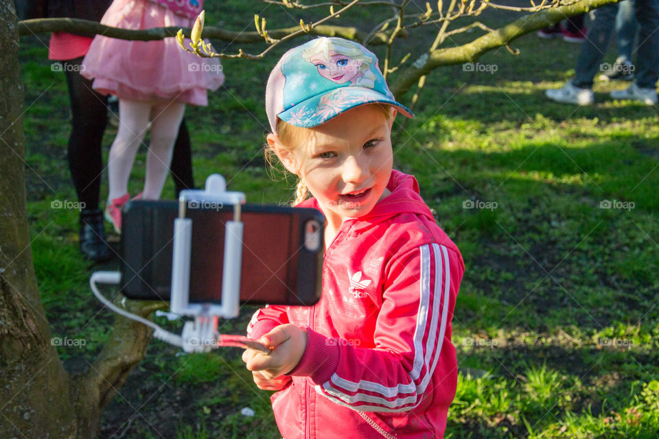 Young girl using a selfiestick to take a selfie in Lund Sweden.