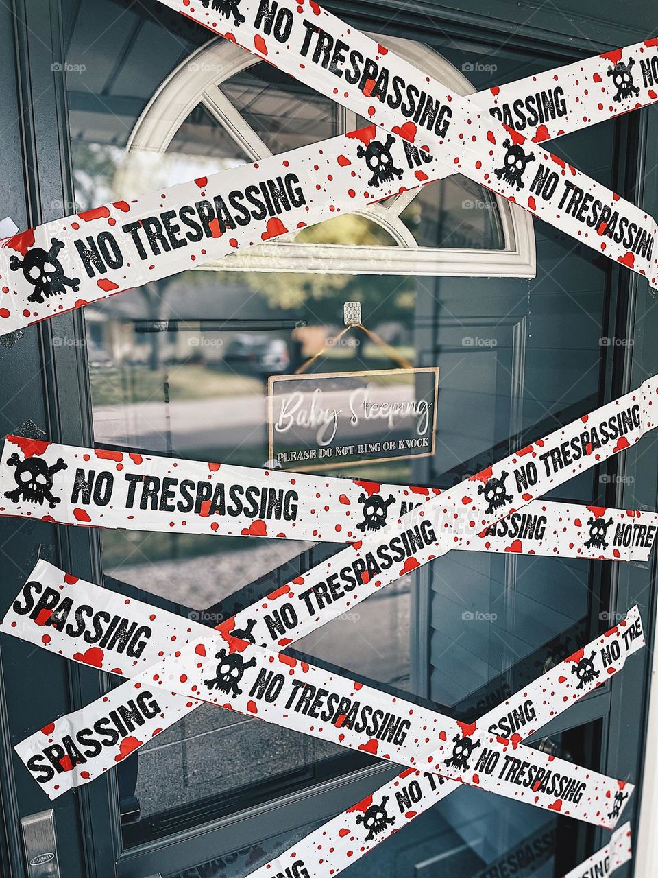 No trespassing scary tape on door, no trespassing blood splattered tape on door, front door messages, no trespassing but also baby sleeping, front door of home