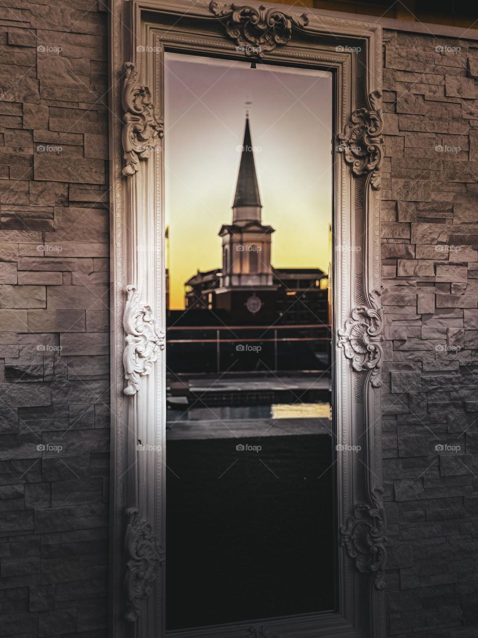 Church steeple illuminated through balcony mirror