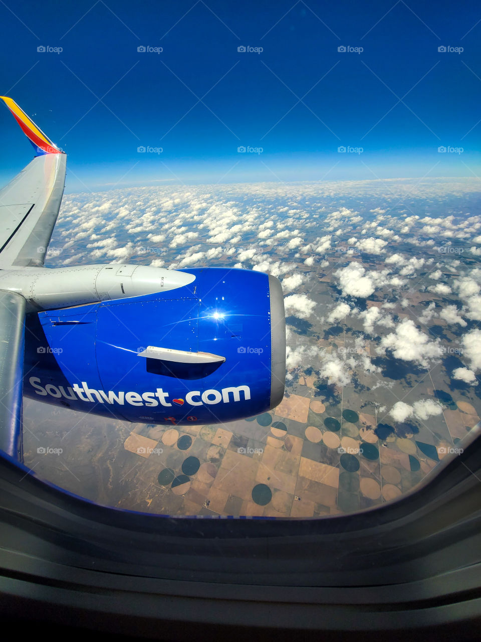 38000 feet above the Midwest United States,  this Southwest Airlines jet slices through a beautiful blue sky dotted with fine cumulus clouds