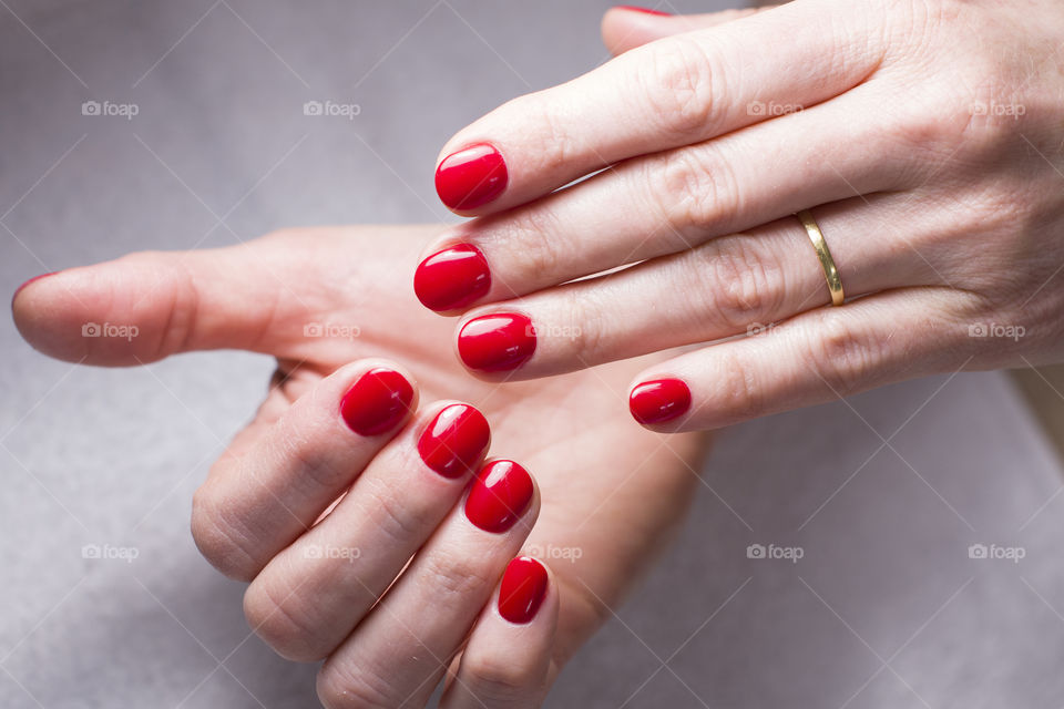 well-groomed hands of a married woman and manicure with red lacquer