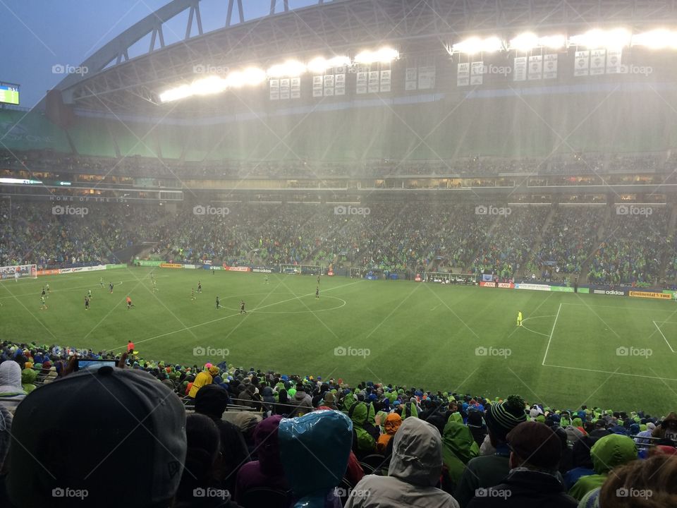 At the Century Link stadium in Seattle at a Sounders game with rain.