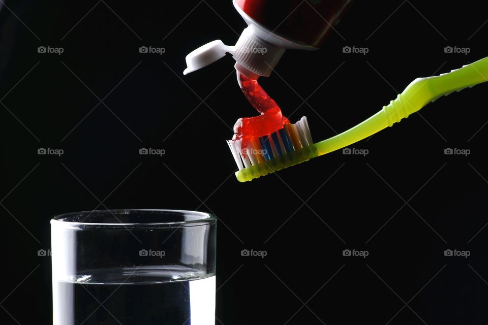 toothbrush, toothpaste and glass of water