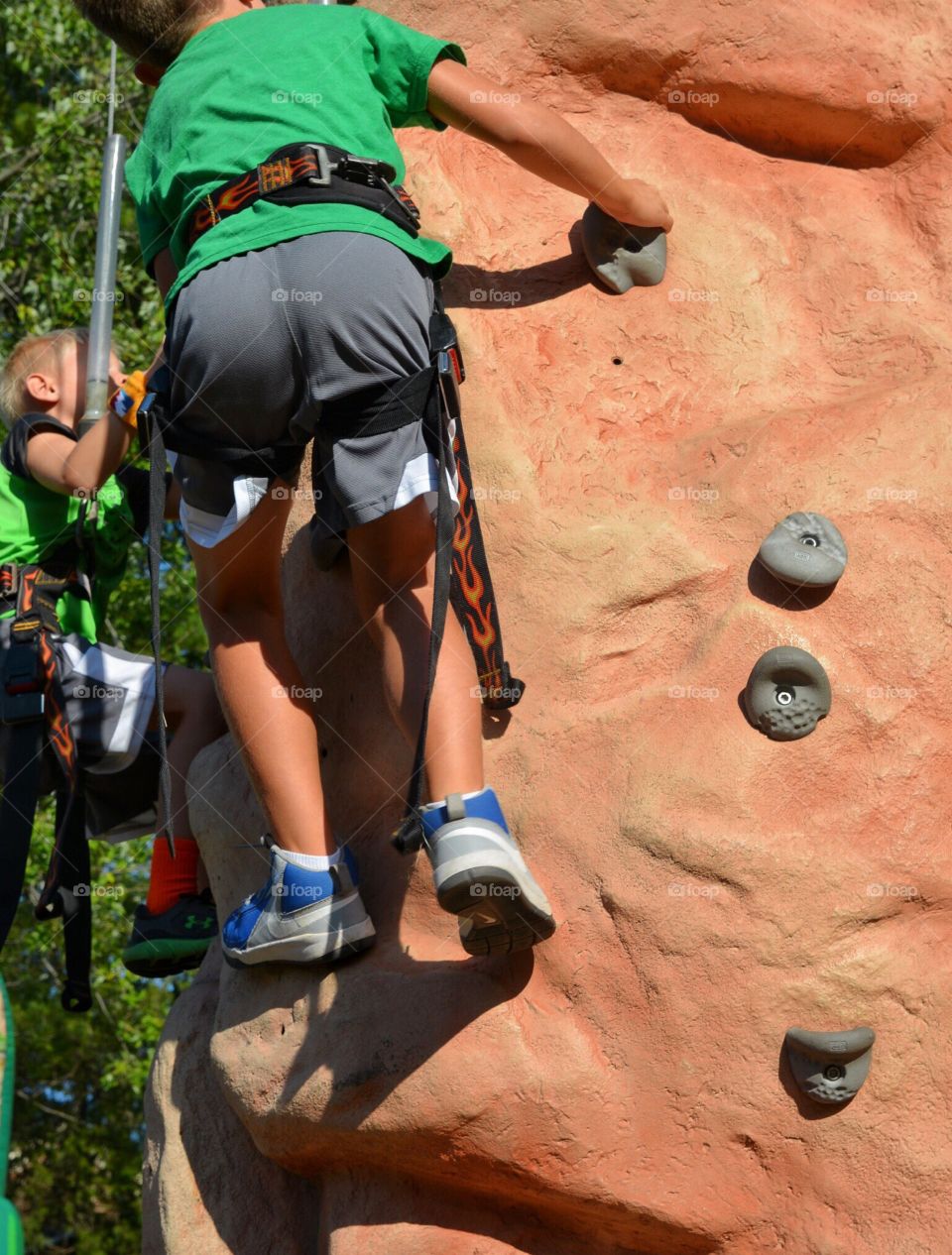 Boys climbing rock wall