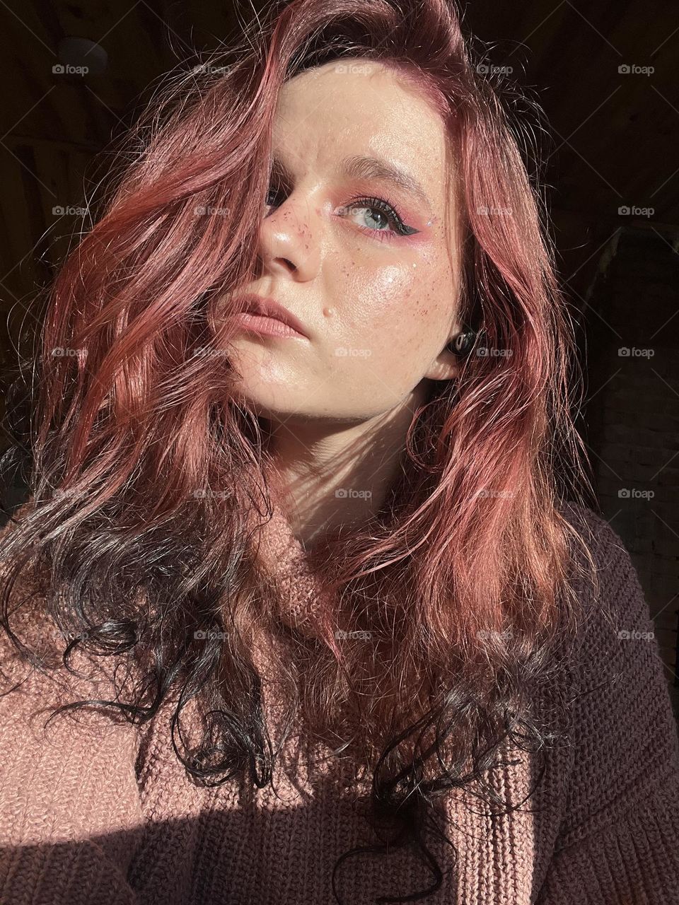 Self portrait in sunny winter day, girl with blue-grey eyes and curly magenta hair