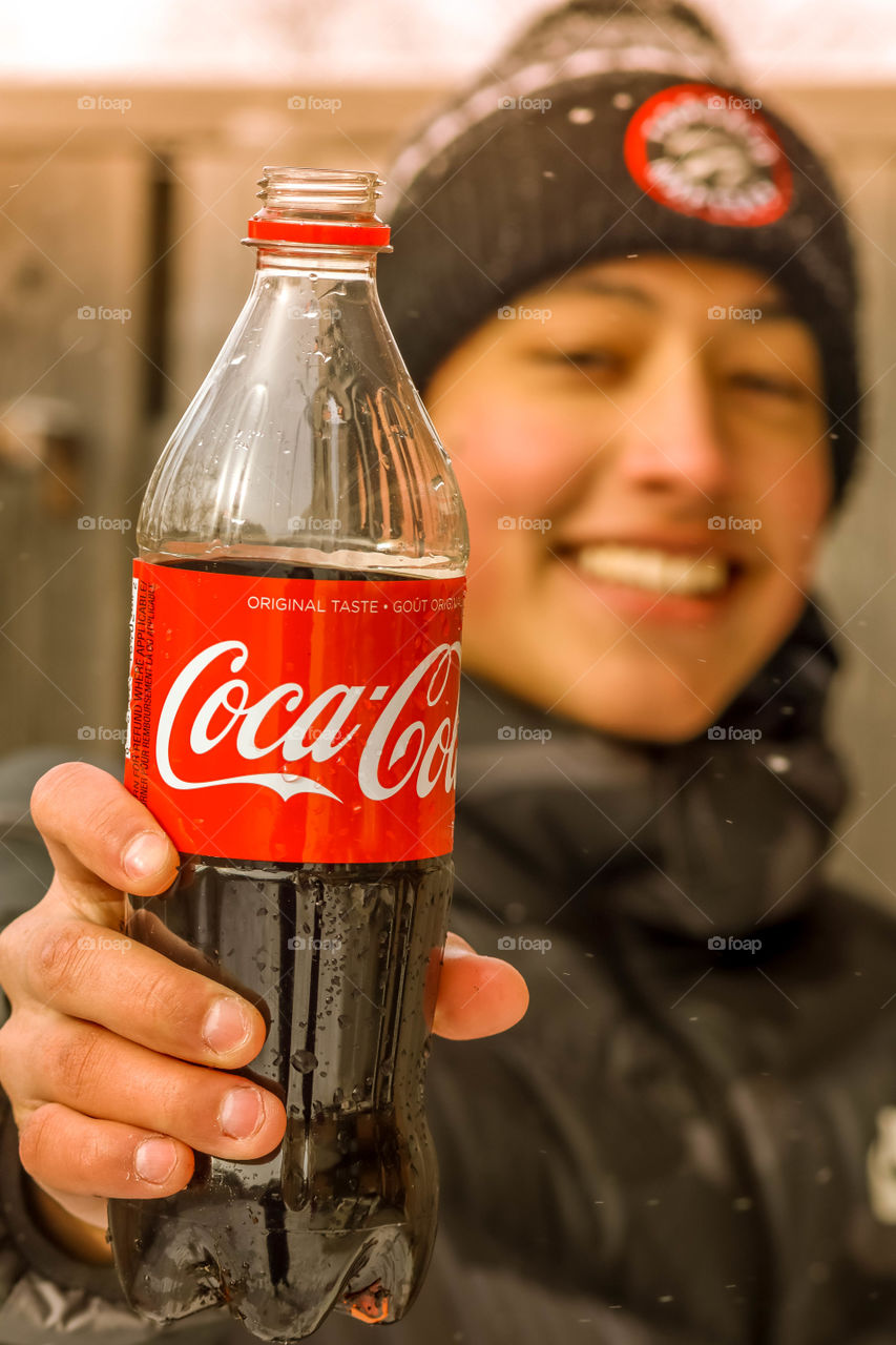 Happy teenager with a bottle of coca cola