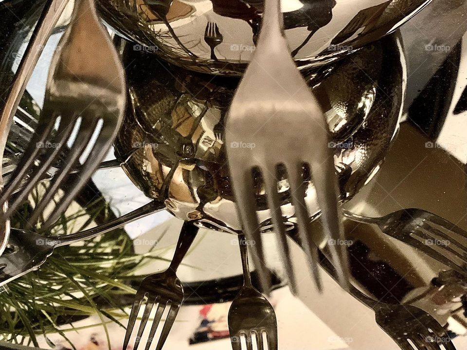 Forks reflecting over top of a mirror 