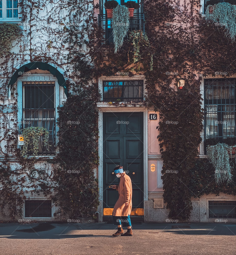 Man is walking in the city with a mask