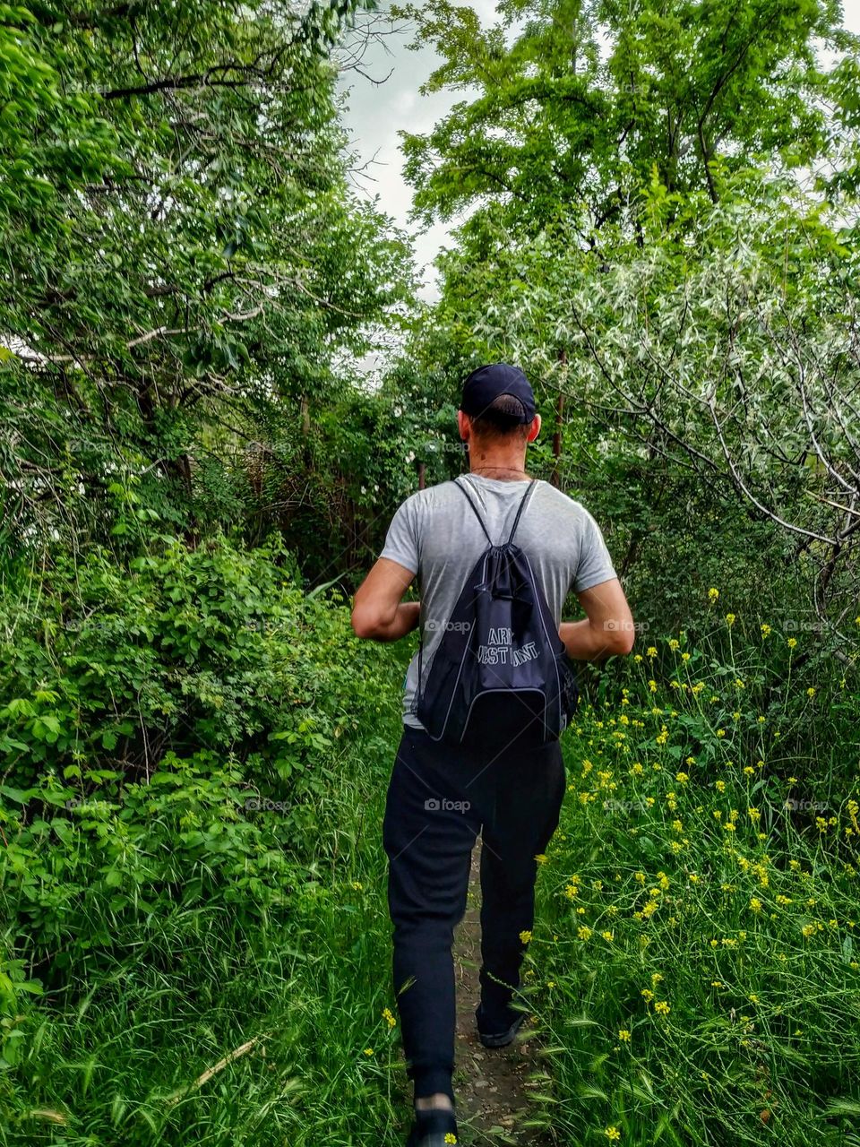 A man with a backpack in a green forest