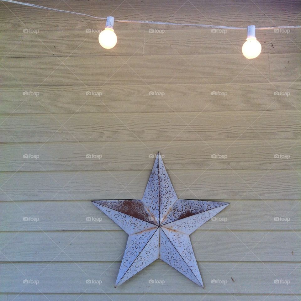 Super Star. White star on wall with lights above