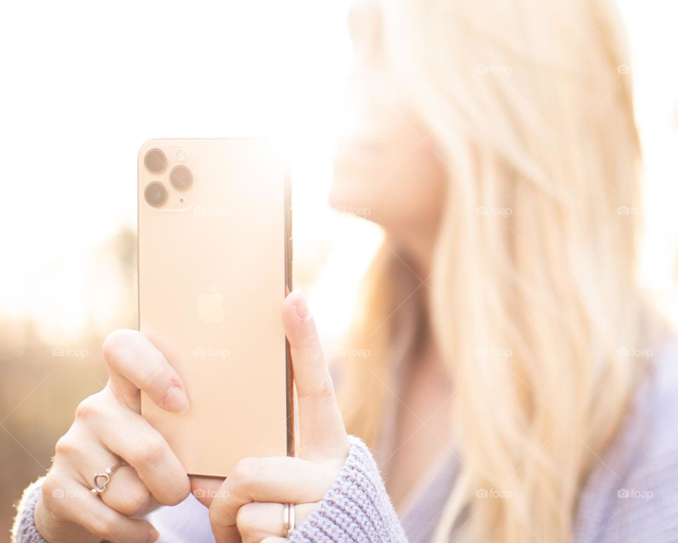 Woman using iphone on a sunny day