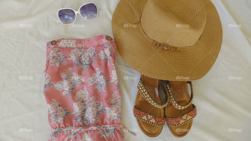 flat lay pink summer dress, sunglasses, sandals, straw hat