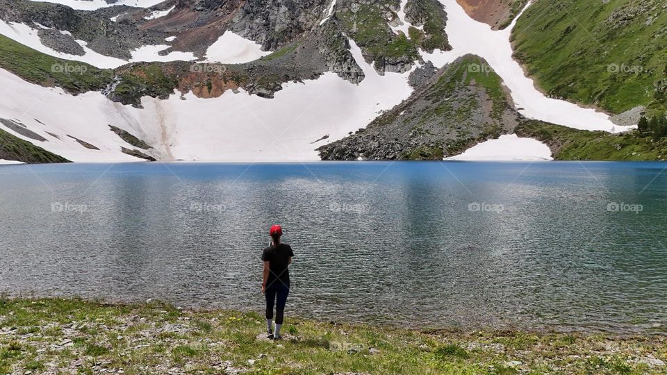 girl tourist near the lake against the backdrop of mountains