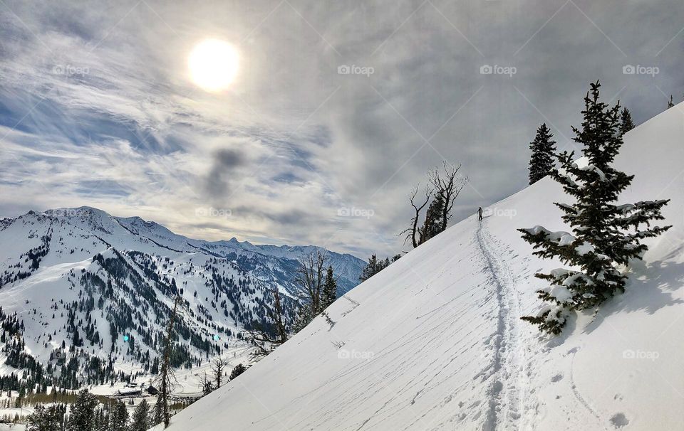 Traveling along a lonely hike in the Wasatch mountains of Utah, looking for fresh turns to ski powder 