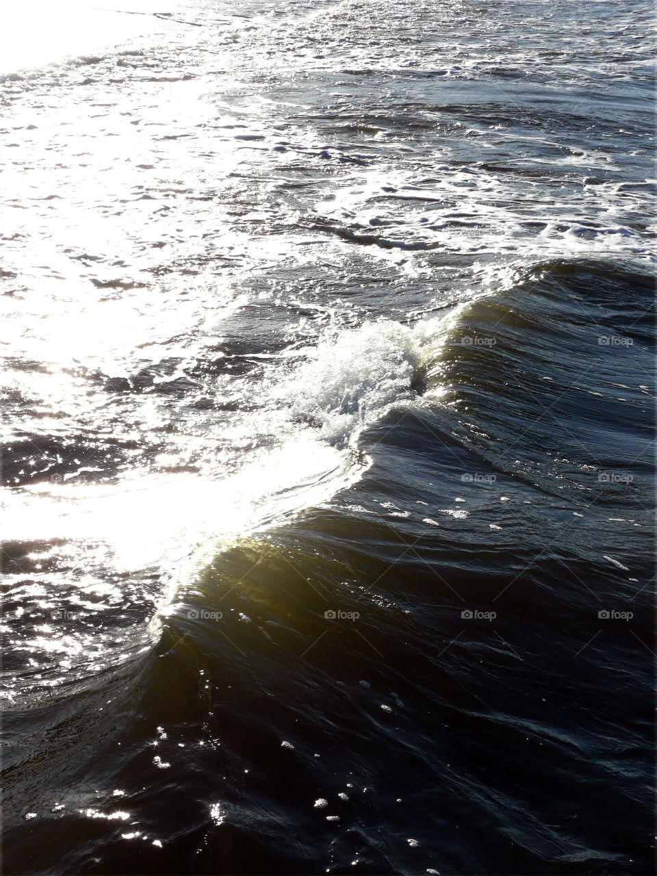 Waves of the Baltic Sea reflecting sunshine in Niechorze, Poland.