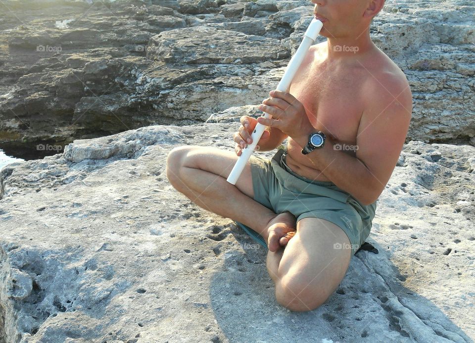 men training yoga meditation on a sea stone shore