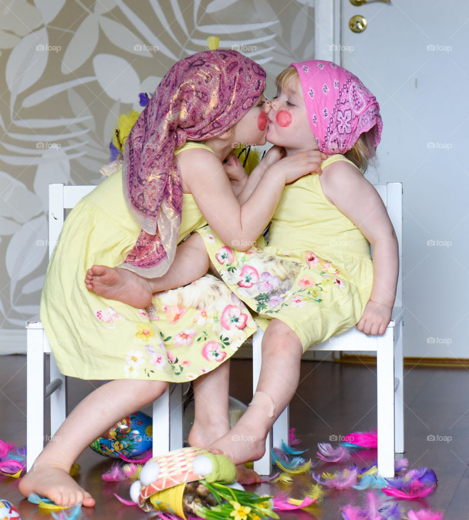 Two young sisters having fun infront of the camera with easter theme.