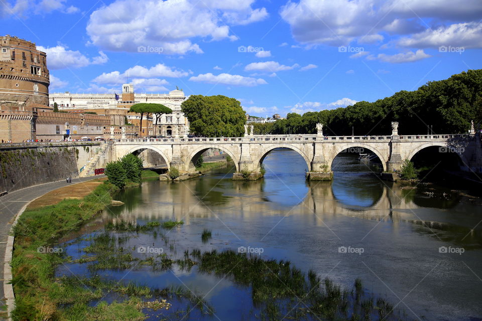 reflections into the water of the arches of the bridge